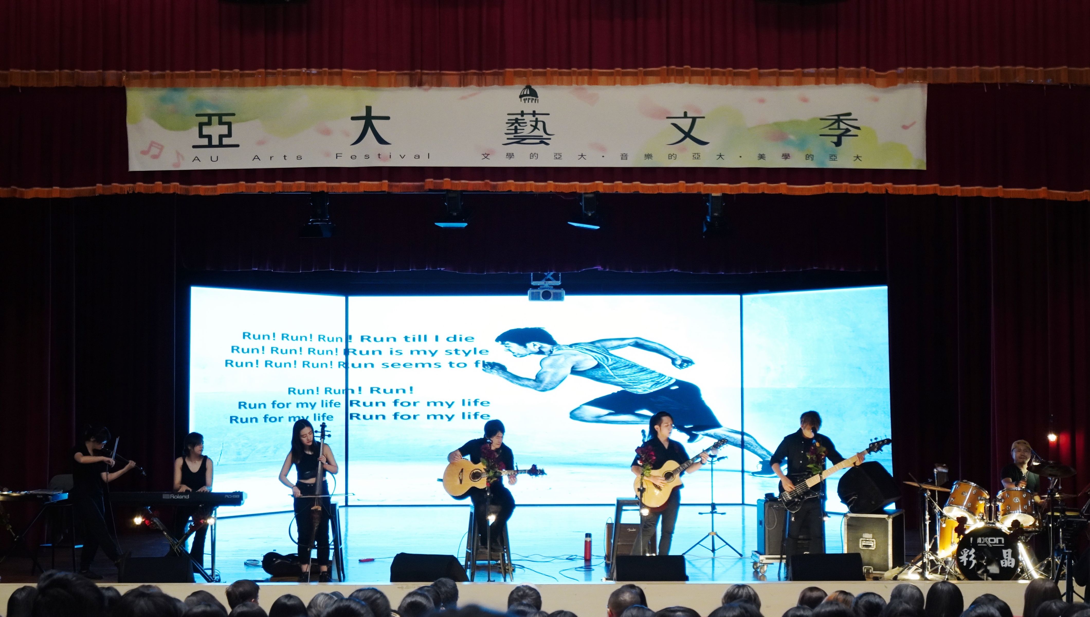 圖說1 2025亞大藝文季壓軸獻禮，邀請到「玫瑰墓樂團」蒞校登台演奏，結合吉他、鼓、弦樂與鍵盤等多樣編制，以搖滾樂風詮釋真實生命故事，現場氣氛熱烈、情感濃厚。